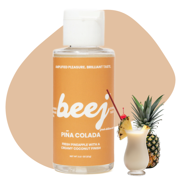 Beej Pina Colada edible massage oil with a cocktail and pineapple on a beige background